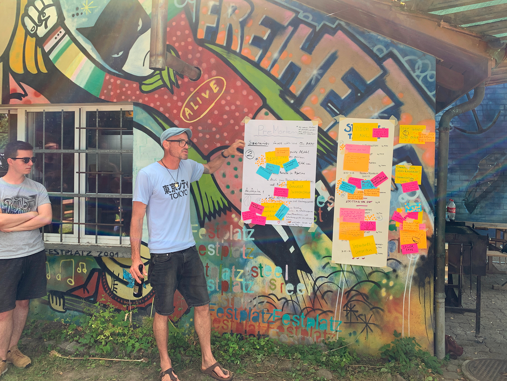 Michael Schranz steht vor einer Wand voller Post-its und erklärt am Strategietag