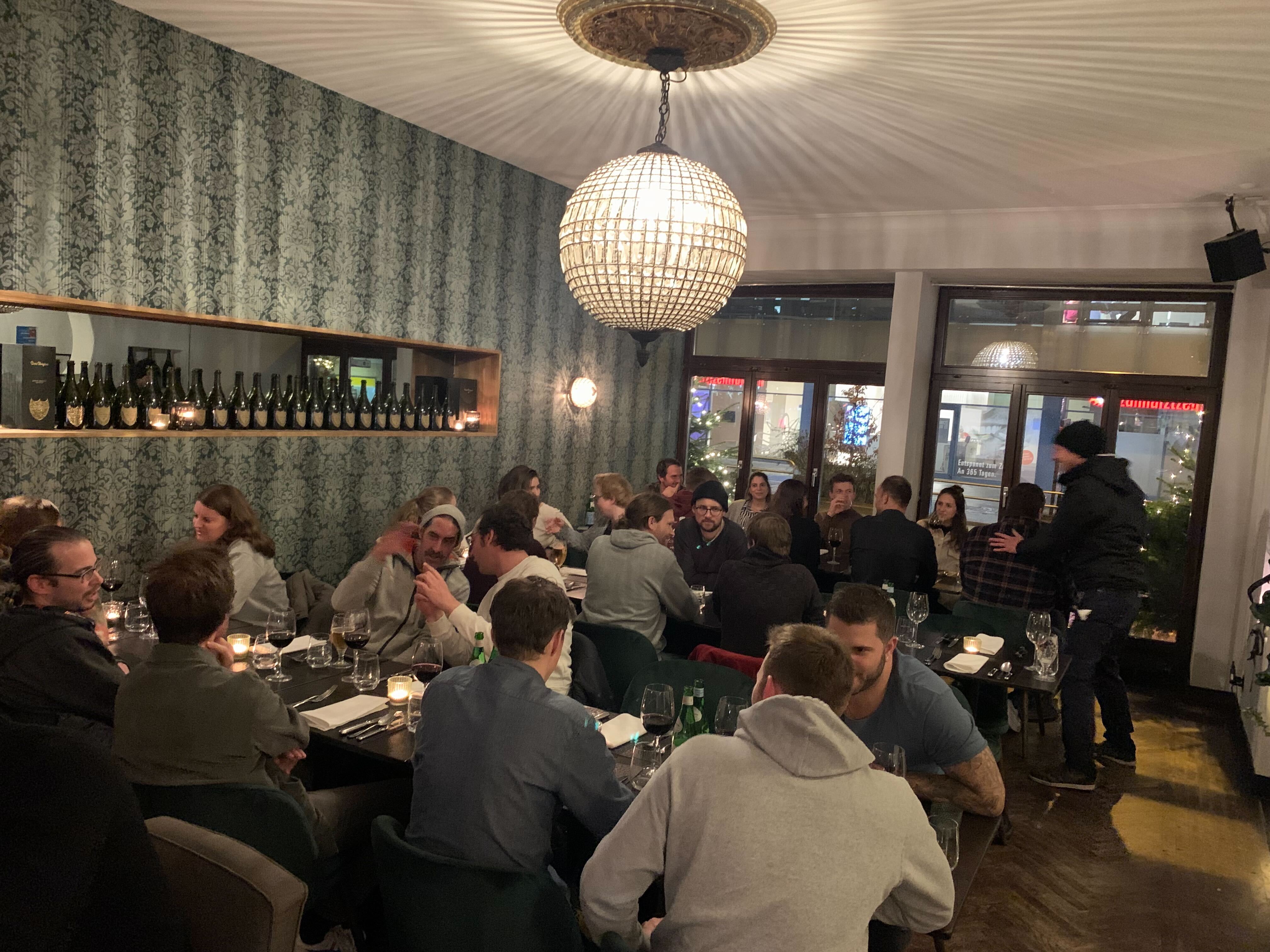 Das Team an mehreren Tischen beim Abendessen