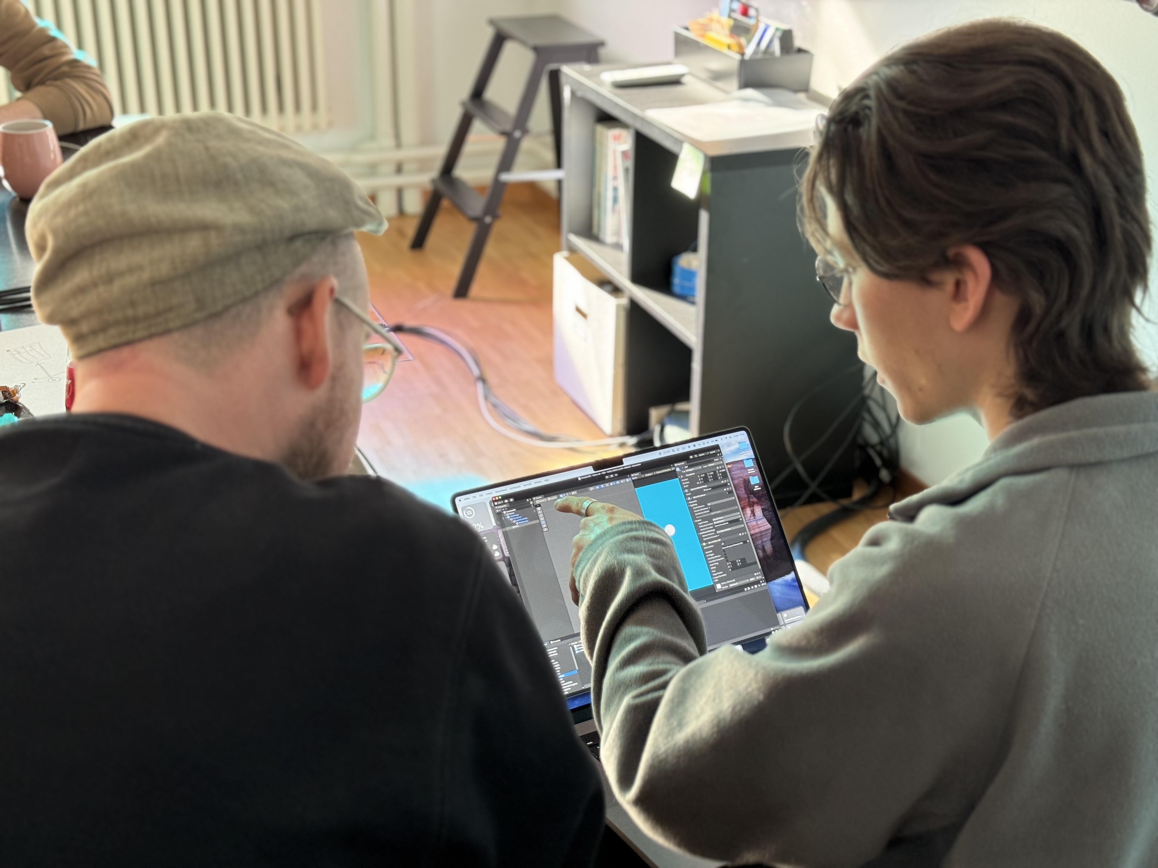 Jann Fiedler zeigt auf den Bildschirm seines Laptops