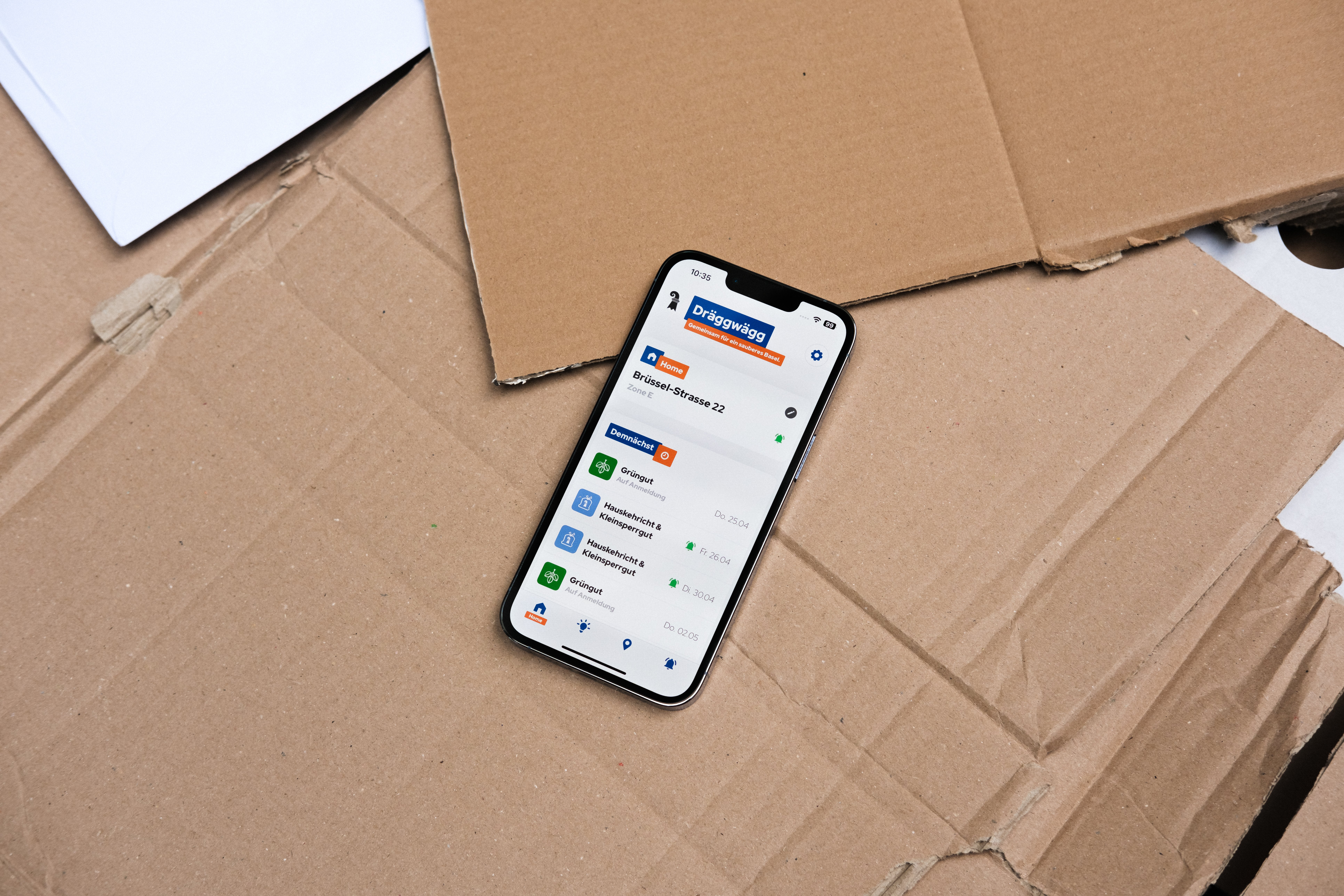 Dräggwägg App geöffnet auf einem iPhone, das auf Karton liegt.