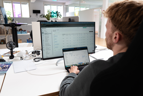 Person schaut auf Laptop und Screen, auf denen SEMRush und Google Analytics Dashboard geöffnet sind.