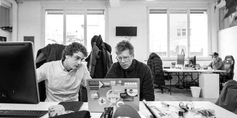 Corsin und Adrian schauen gemeinsam auf einen Laptop