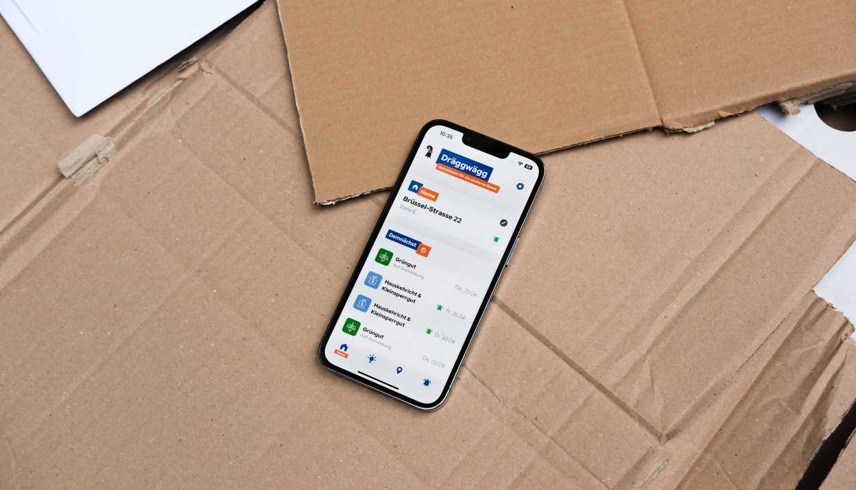 Dräggwägg App geöffnet auf einem iPhone, das auf Karton liegt.