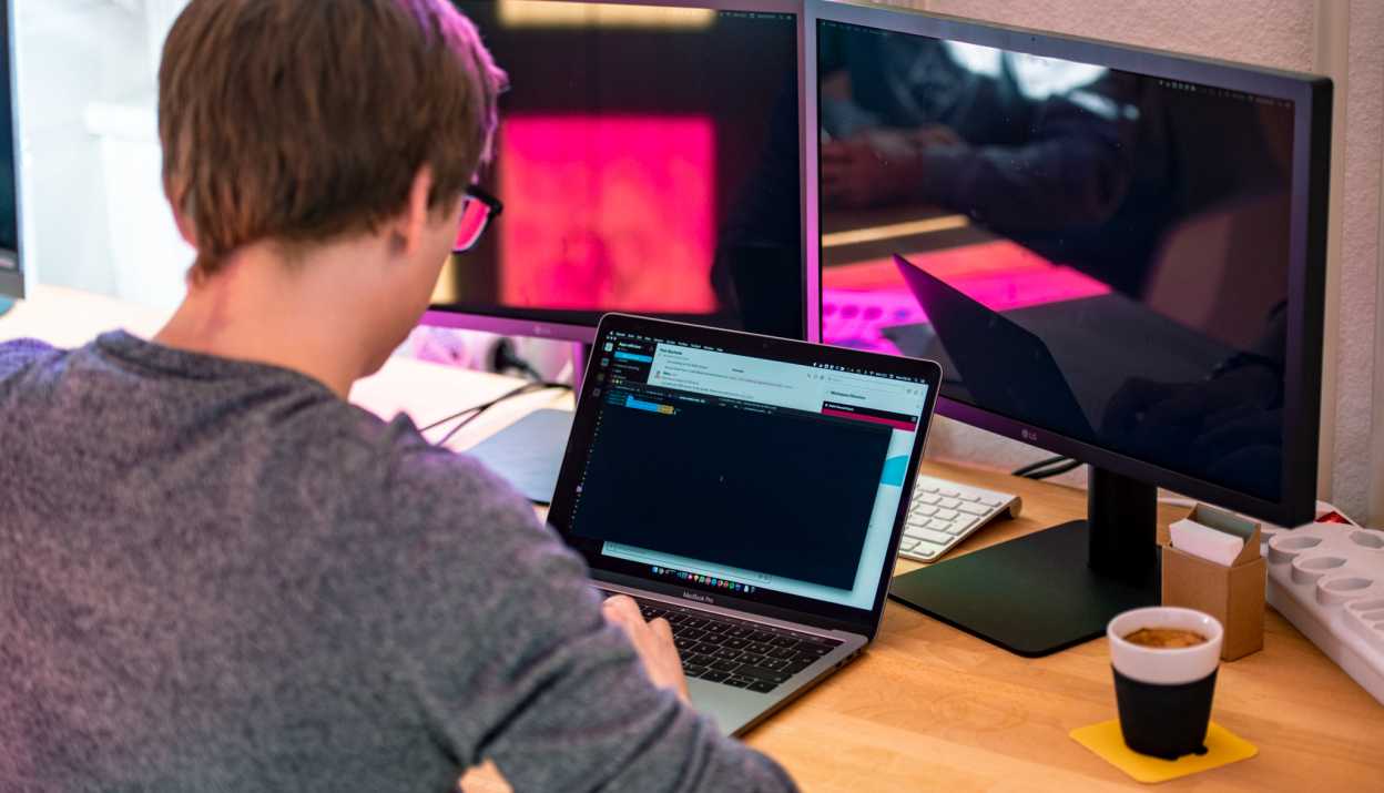 website und webapp entwicklung software code auf dem Bildschirm eines Mitarbeitenden von Apps with love