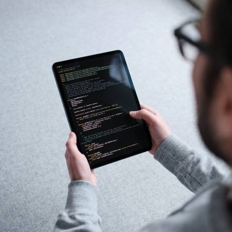 Person holds iPad in hands on which part of a smart contract is displayed