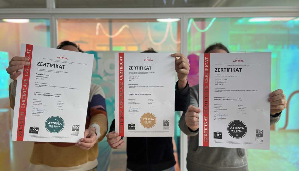 Three 'Apps with love' staff members holding their ISO certificates