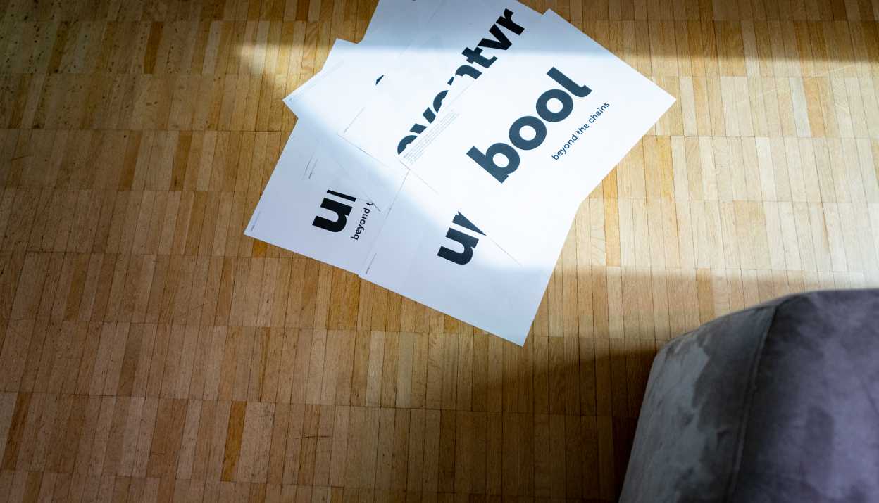 White A3 sheets with various brand names and claims lie on a parquet floor