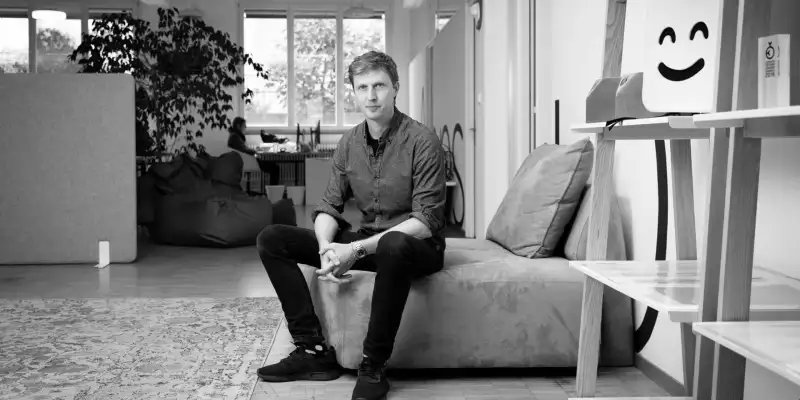 Till Könneker sits on a sofa in the Apps with love office in Bern